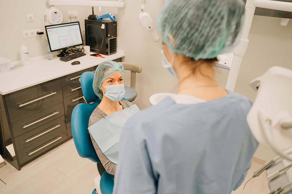 Odontóloga en la consulta con una paciente antes de una elevación de seno