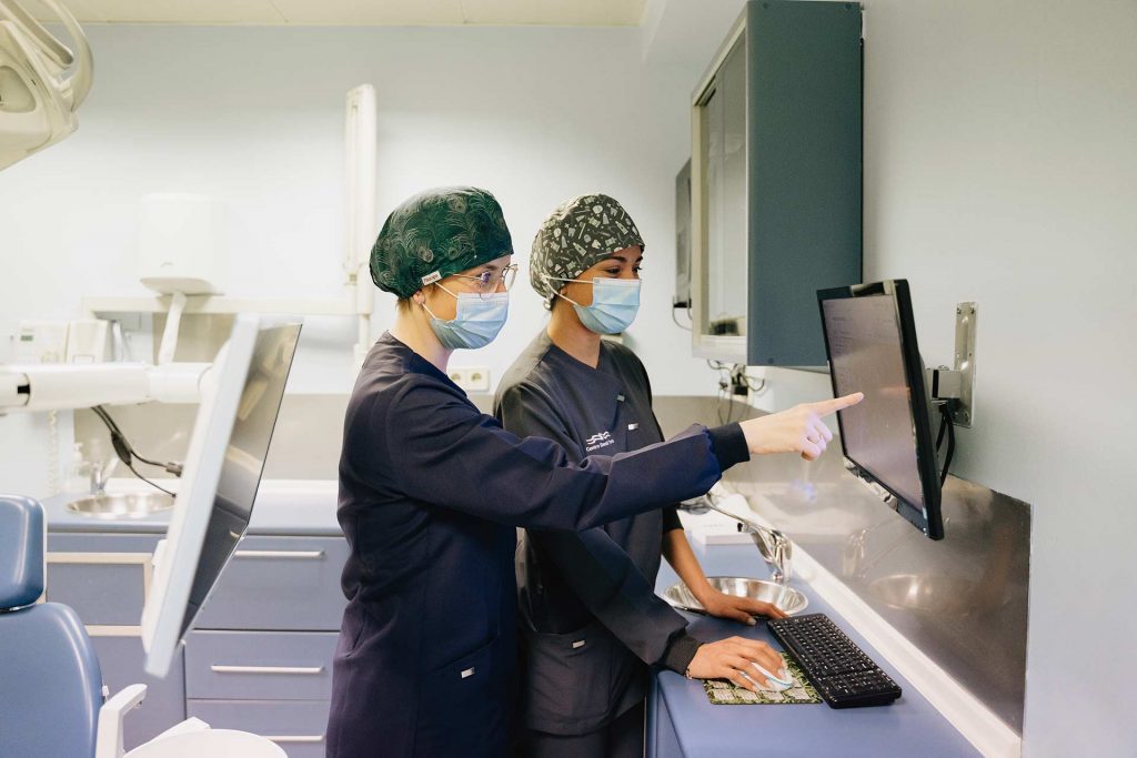 Dos odontólogas de la clínica dental Torres revisando una radiografía de un paciente en un ordenador