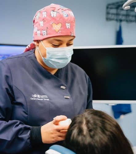 Odontóloga de la clínica dental Torres realizando una revisión a un paciente