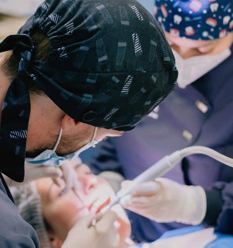 Dentista de la clínica dental Torres realizando una limpieza dental a un paciente