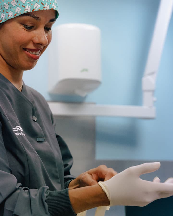 Dentista de la clínica dental Torres poniéndose unos guantes antes de una intervención con láser