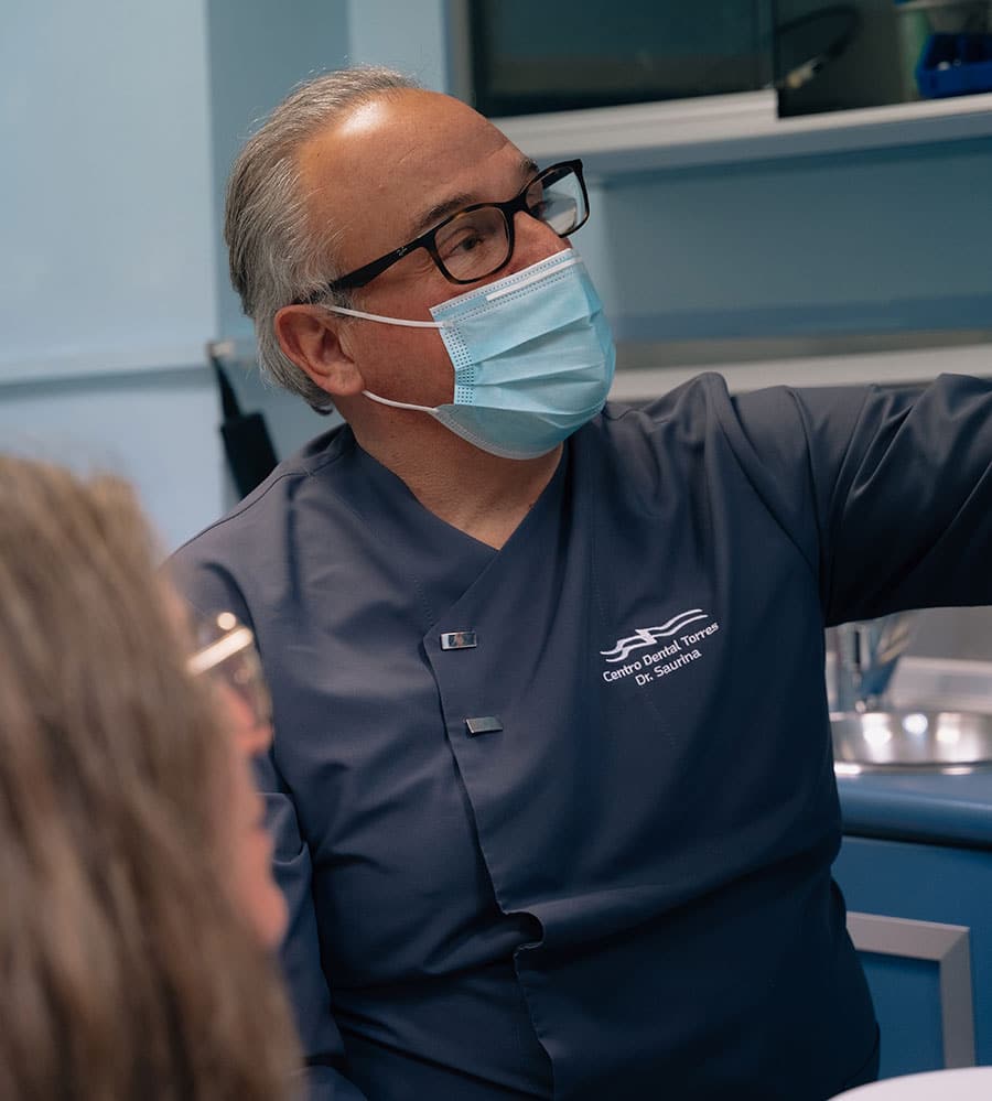 Odontólogo del Centro Dental Torres mostrando a una paciente cómo se hará una intervención con láser dental
