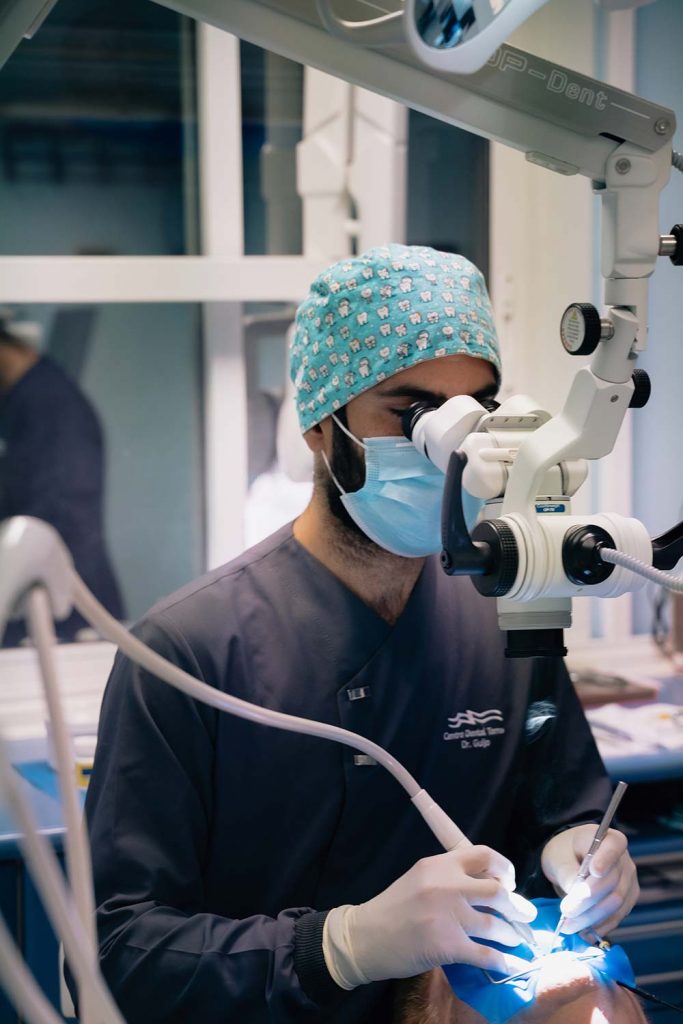 Odontólogo del Centro Dental Torres realizando una endodoncia con microscopio a un paciente